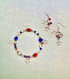 This sparkly and patriotic Bracelet and Earring set is handmade using crystal, glass, and Tibetan silver beads with silvery star charms.  Comes in an elegant red sachet with description card. Can be converted to clip ons for non-pierced ears, or sterling silver for sensitive pierced ears. Red Star-shaped Beaded Jewelry, Silver Jewelry For 4th Of July Gift, Silver Jewelry Gift For 4th Of July, Patriotic Dangle Jewelry For Gifts, Patriotic Round Beads Jewelry Gift, Patriotic Silver Jewelry For Independence Day, Red Dangle Jewelry For Independence Day, Handmade Patriotic Silver Jewelry, Patriotic Bracelet