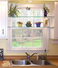 a kitchen with white cabinets and wooden counter tops, along with a window over the sink