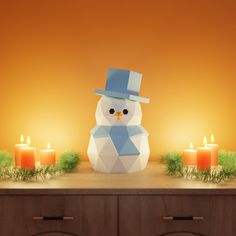 an origami snowman sitting on top of a table next to some candles