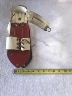 a pair of red and white shoes sitting on top of a floor next to a ruler