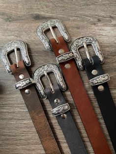 This gorgeous belt is one of our most popular products. We offer it in 4 colors of premium 8-9 ounce buffalo leather and in a tooled leather finished in antique tan. Features a beautiful western floral buckle, loop and tip. Your choice of buffalo leather in matte black, crazy horse brown, crazy horse gray, or golden brown or tooled and finished in saddle tan. The western floral buckle, loop and tip are die cast and set in a beautiful antiqued silver plate. 1.0-inch width. Cut to your personal si Leather Belts With Antique Buckle For Rodeo, Hand Tooled Leather Belt Buckles For Rodeo, Rustic Leather Belt Buckles For Rodeo, Hand Tooled Leather Belt Buckles For Ranch, Leather Concho Belt Buckles For Rodeo, Classic Concho Belt For Western-themed Events, Western Belts And Suspenders With Antique Buckle, Western Belts And Suspenders With Antique Buckle For Ranch, Classic Hand Tooled Belt Buckles For Western-themed Events