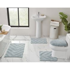 a bath room with a toilet a sink and a bath tub next to a window