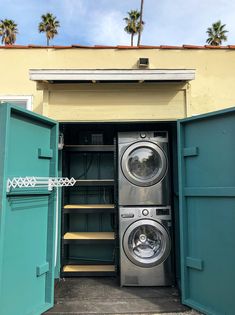 a washer and dryer are in the open door of a storage unit with palm trees