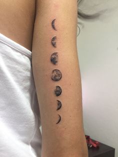 a woman's arm with phases of the moon tattoo on it