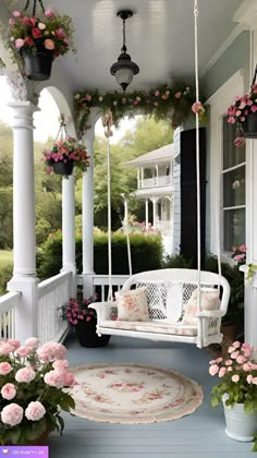 a white porch swing with pink flowers on it and potted plants hanging from the ceiling