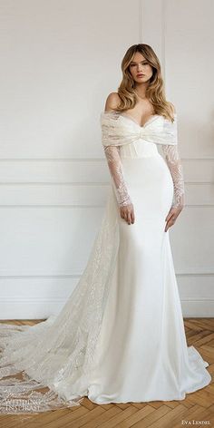 a woman in a white wedding dress with long sleeves and an off - the - shoulder top