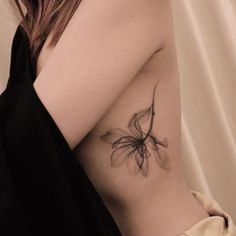 a woman's arm with a flower tattoo on the left side of her body