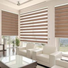 a living room filled with white furniture and windows covered in roman blind shades on top of them