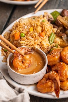 shrimp, rice and vegetables on a plate with chopsticks