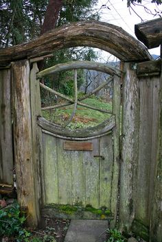 an old wooden gate with moss growing on it