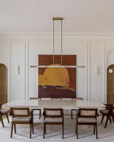 a dining room table with chairs and a painting on the wall