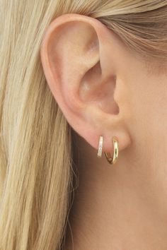 a close up of a woman's ear with two small hoops on it