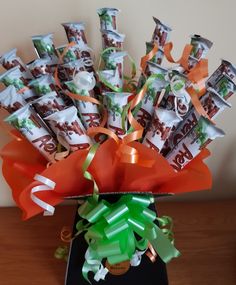 an arrangement of candy wrapped in orange and green ribbons