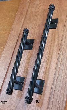 two pieces of wood with black metal handles on each end and one piece of rope attached to the other side