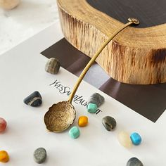 a piece of jewelry sitting on top of a table next to some rocks and stones