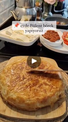 a wooden cutting board topped with food on top of a stove