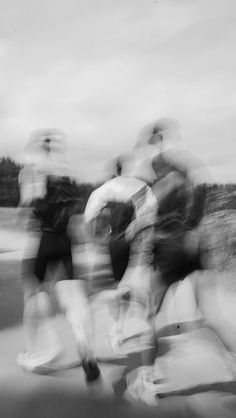 black and white photograph of people riding skateboards on the street with blurry background