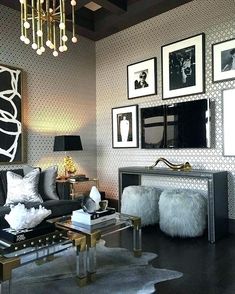 a black and white living room with pictures on the wall, chandelier and couches