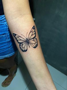 a small butterfly tattoo on the arm