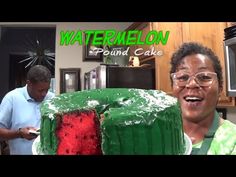 a man standing in front of a green cake