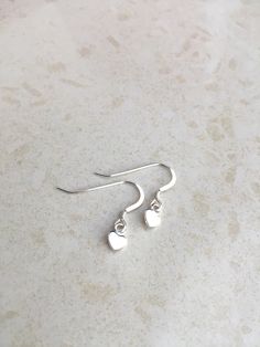 Delicate and Feminine Heart Earrings! Made with an unwon pair of 925 sterling silver earring hooks (includes clear earring backing) Heart is 925 sterling silver Length .5 inch Width .25 inch Sterling Silver Earrings With Ear Wire For Mother's Day, White Sterling Silver Heart Charm Earrings, Adjustable Silver Heart Earrings For Gift, Dainty Heart Drop Earrings For Gift, Nickel-free White Sterling Silver Heart Earrings, White Sterling Silver Double Heart Earrings, Heart Dangle Earrings As Gift, Adjustable Silver Heart Earrings, Dainty Teardrop Heart Earrings For Gift