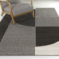 a chair sitting on top of a rug next to a gray and white carpeted floor