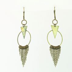 These fun geometric charm earrings come in a subtle antique brass finish. Each earring has a cascade of dainty chains hanging from a hoop in a chainmail reminiscent pattern. These bold and lively earrings are sure to make an impression. With a matching necklace available, this would make a fabulous gift set! -Geometric triangle and hoop charm -hanging chain accents -Antique brass finish -Leverback earring closure Bronze Metal Dangle Chandelier Earrings, Nickel Free Triangle Metal Earrings, Geometric Nickel-free Metal Earrings, Nickel-free Geometric Metal Earrings, Nickel-free Metal Triangle Earrings, Bohemian Geometric Metal Jewelry, Handmade Triangle Brass Jewelry, Nickel-free Triangle Bohemian Jewelry, Bohemian Triangle Nickel-free Jewelry