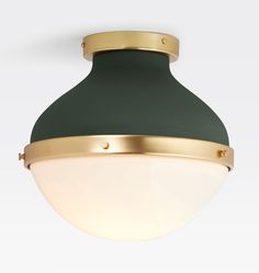 a green and gold light fixture on a white wall