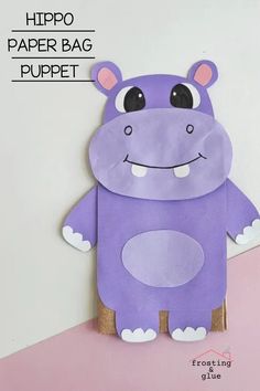 a purple hippo paper bag puppet sitting on top of a pink surface with text overlay that reads, hippo paper bag puppet