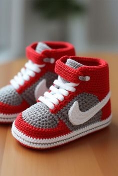 a pair of crocheted sneakers sitting on top of a wooden table