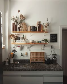 the kitchen counter is covered with pots, pans and other items on shelves above it