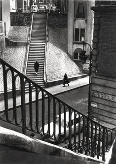 a black and white photo of a person on a skateboard going down the stairs