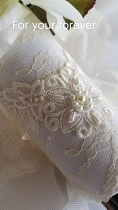 white wedding garter with flowers and text for your forever written on the front side