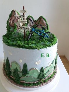 there is a cake that looks like it has a mountain scene on top and a bike in the middle