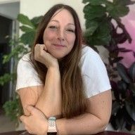 a woman sitting at a table with her arms crossed