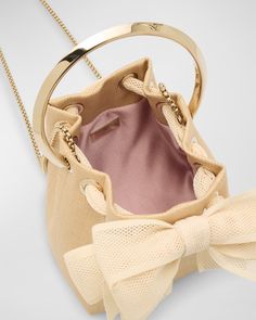 Jimmy Choo "Bon Bon" bucket bag in nylon, polyester, and faux leather (polyurethane)     Metal top handle     Chain crossbody strap    Can be worn as a top handle or crossbody bag     Open top with bow drawstring closure     Approx. 5.9"H x 5.5"W x 3.7"D    Item Weight (Lbs.): 0.8    Made in Italy Jimmy Choo Bon Bon Bag, Bon Bon, Open Top, Crossbody Strap, Jimmy Choo, Top Handle, Bucket Bag