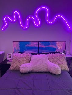 a bed with pillows and neon lights on the wall