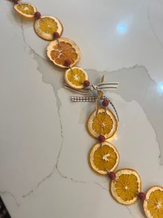 orange slices are arranged in a line on a counter top, with beads attached to them