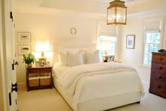 a bedroom with white bedding and two lamps