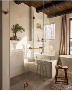 a bathroom with a bathtub, sink and stool next to a window in the room