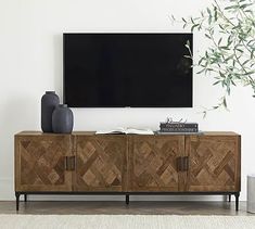 a flat screen tv sitting on top of a wooden cabinet