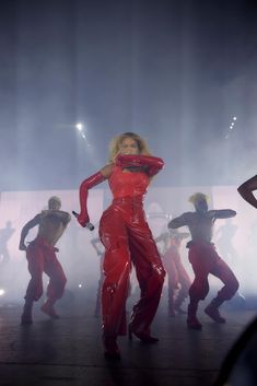 a woman in red is dancing on stage