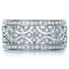 an intricate wedding band with diamonds on the sides and in the middle, surrounded by filigrees