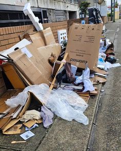 a pile of cardboard boxes and other items on the sidewalk