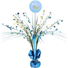 a vase filled with blue and gold stars on top of a white table next to a baby's first birthday sign