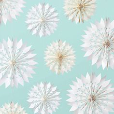 a blue and white wallpaper with paper snowflakes hanging from it's sides