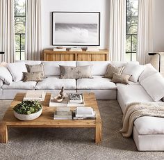 a living room filled with lots of white furniture and decor on top of carpeted flooring