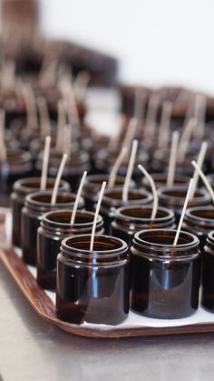 small jars with toothpicks are lined up on a tray