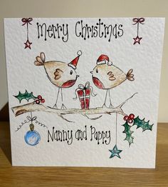 a christmas card with two birds on a branch