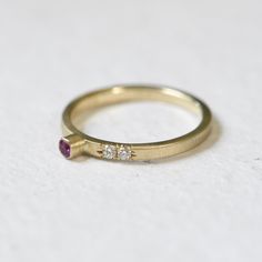 She's a little different. This is a 10k yellow gold ring with a stunning natural pink sapphire in a tube setting with a touch of pave on one side of the band. About this Ring: -Features a responsibly sourced natural pink sapphire 3mm and two 1.8mm SI1 diamonds -Certified recycled 10k yellow gold -The band measures 2mm in width. -Band has a satin finish. -The inside of the ring is marked with "10K" twice, LOL woopsies. -Size 7. Can be potentially resized up or down a size or two, no charge just l Tube Setting, Yellow Gold Ring, Pink Sapphire, Yellow Gold Rings, Satin Finish, Precious Metals, Gold Ring, Ring Earrings, Charm Necklace